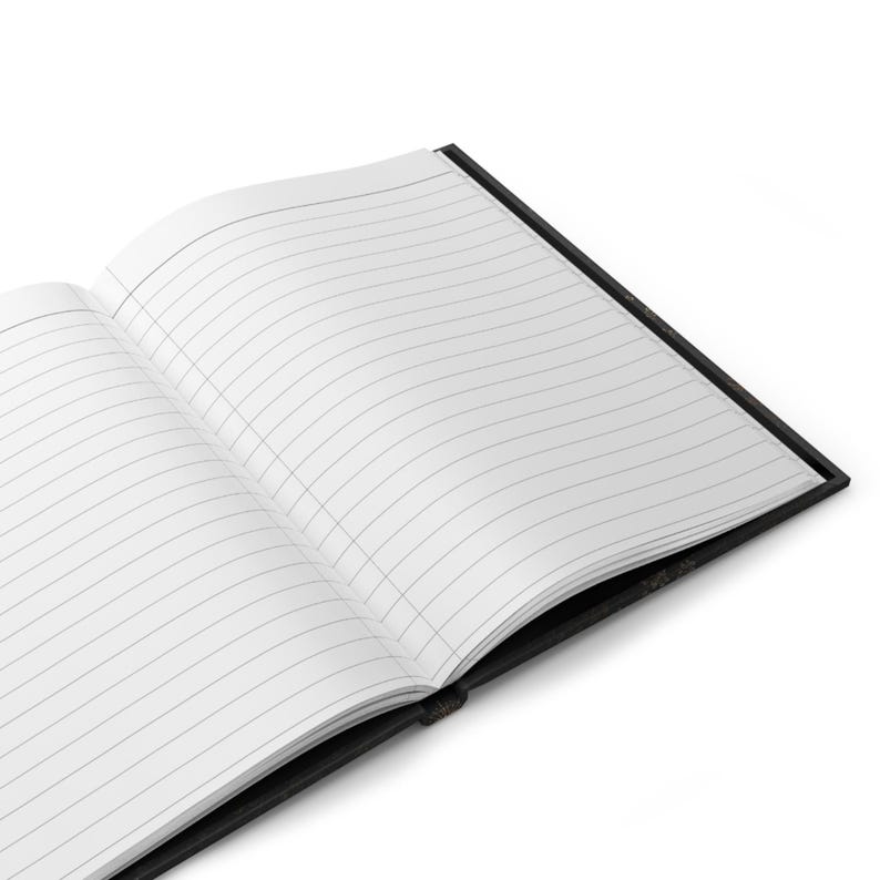 An open hardcover notebook reveals blank white lined pages against a plain background.