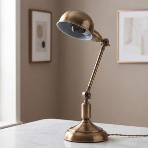 Classic brass bedside lamp on a white side table in a soft modern interior
