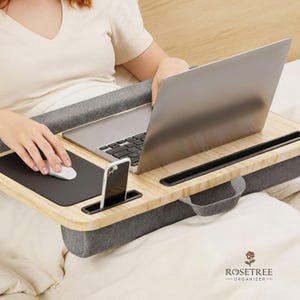 May include: A white ceramic mug with a black handle and the text "But First, Coffee" in a bold, black font. The mug is set against a blurred background, suggesting a cozy setting.