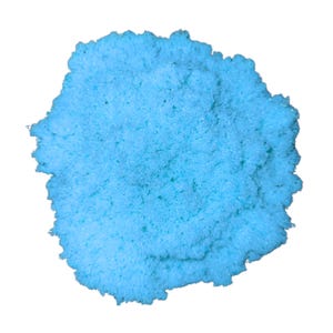 May include: A close-up of a pile of light blue powder against a white background. The powder has a textured, granular appearance, with variations in shade. The overall shape is irregular, resembling a cloud or a small, fluffy mass.