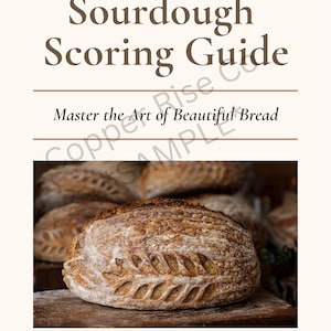 May include: A guide titled "Sourdough Scoring Guide" with the text "Master the Art of Beautiful Bread." The image features a loaf of bread with decorative scoring. The Copper Rise Co. logo is at the bottom.