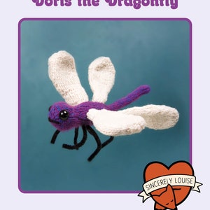 May include: Knit your own Doris the Dragonfly knitting pattern. The pattern features a purple dragonfly with white wings and black legs. The pattern is from Sincerely Louise.