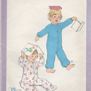 Könnte beinhalten: Simplicity-Schnittmuster 8693 für einen Overall für Kleinkinder. Die Illustration zeigt zwei Kleinkinder, eines in einem blauen Overall und das andere in einem Overall mit floralem Muster. Das Muster enthält Anweisungen für Größe 3. Der Text "ABC" ist sichtbar.