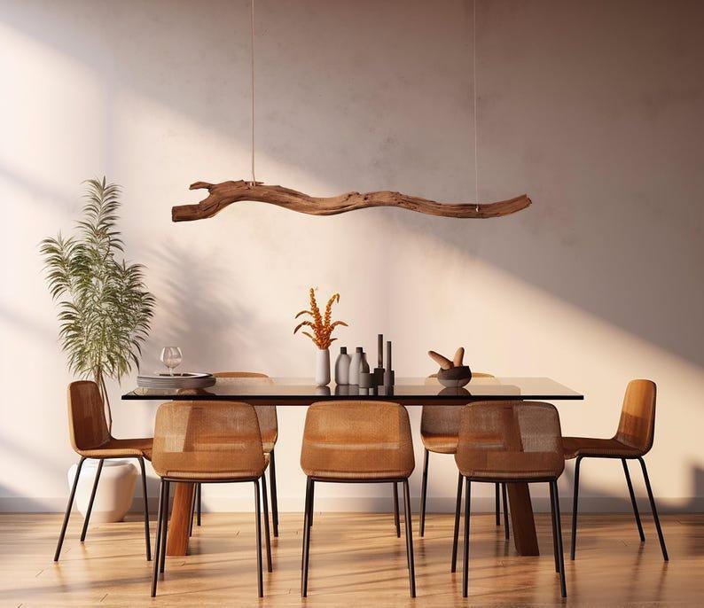 May include: A modern dining room set with a glass table, six chairs, and a wooden branch light fixture. The chairs have brown woven seats and black metal legs. Decorative vases and candles are on the table.