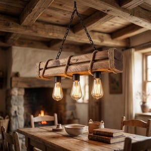 May include: A rectangular wooden beam pendant light fixture suspended by black metal chains. The beam is wrapped with thick natural rope at both ends and the centre. Three Edison-style light bulbs hang downwards from black sockets.