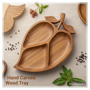 Puede incluir: Una bandeja de madera tallada a mano con forma de hoja, dividida en tres secciones. La bandeja es de madera marrón claro y presenta un asa en forma de hoja. El texto "Hand Carved Wood Tray" es visible en la parte inferior de la imagen.
