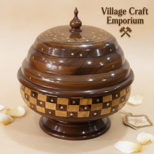 May include: A handcrafted wooden decorative bowl with a lid. The bowl is dark brown with a checkerboard pattern of light brown squares and star accents. The lid has a decorative design and a small finial. The text "Village Craft Emporium" is visible.