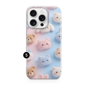 May include: A smartphone case featuring a gradient background transitioning from soft pink to light blue. The surface is decorated with a repeating pattern of small, fuzzy, plush-like animal faces including bears, cats, and bunnies. A black circle with the number 5 is visible on the left side.