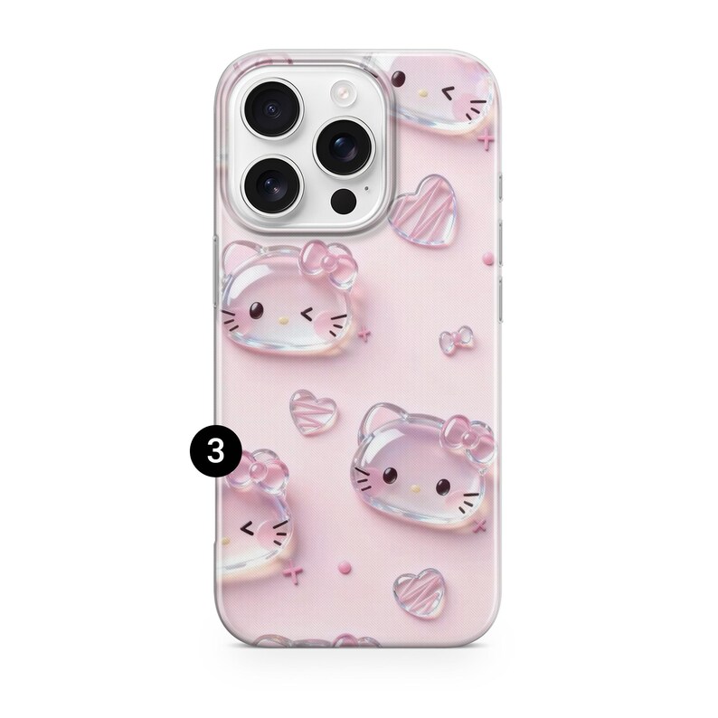 May include: A light pink smartphone case featuring a repeating pattern of translucent, 3D-style Hello Kitty character faces and small hearts. The design includes a black number 3 in a circle on the left side and a camera cutout at the top.