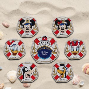 May include: A collection of Disney-themed coasters featuring Mickey Mouse, Minnie Mouse, Donald Duck, Daisy Duck, Goofy, and Pluto. Each coaster is designed as a life preserver with red and white stripes, anchors, and character names.