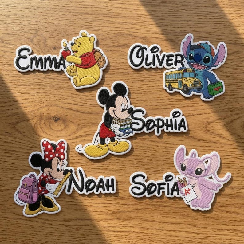 May include: Five embroidered patches featuring Disney characters and names. Winnie the Pooh with 'Emma', Stitch with a school bus and 'Oliver', Mickey Mouse holding books with 'Sophia', Minnie Mouse with a backpack and 'Noah', and Angel with 'Sofia'.