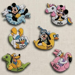 May include: Embroidered patches featuring Disney characters: Mickey Mouse in a float, Minnie Mouse on a unicorn, Donald Duck in a float, Goofy on a duck, Pluto on a dinosaur, and Daisy Duck on a flamingo. Each patch has a name.