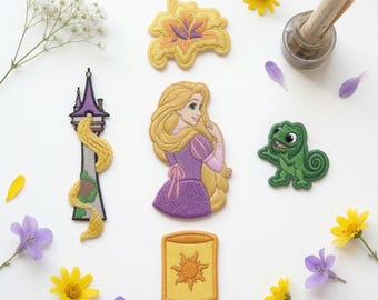 May include: A collection of five embroidered patches featuring a golden flower, a tall tower with long blonde hair, a character with long blonde hair in a purple dress, a green chameleon, and a yellow lantern with a sun design, surrounded by flowers.