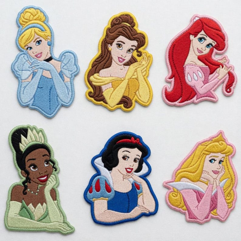 May include: Embroidered patches featuring six different princess designs. Each patch showcases a princess with detailed facial features, hair, and attire. The princesses are depicted in various colors, including blue, yellow, red, pink, green, and white.