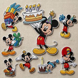 May include: A collection of embroidered patches featuring Mickey Mouse in various birthday-themed poses. Mickey is shown holding gifts, a birthday cake with candles, and wearing a party hat. The patches are in red, yellow, black, and white.