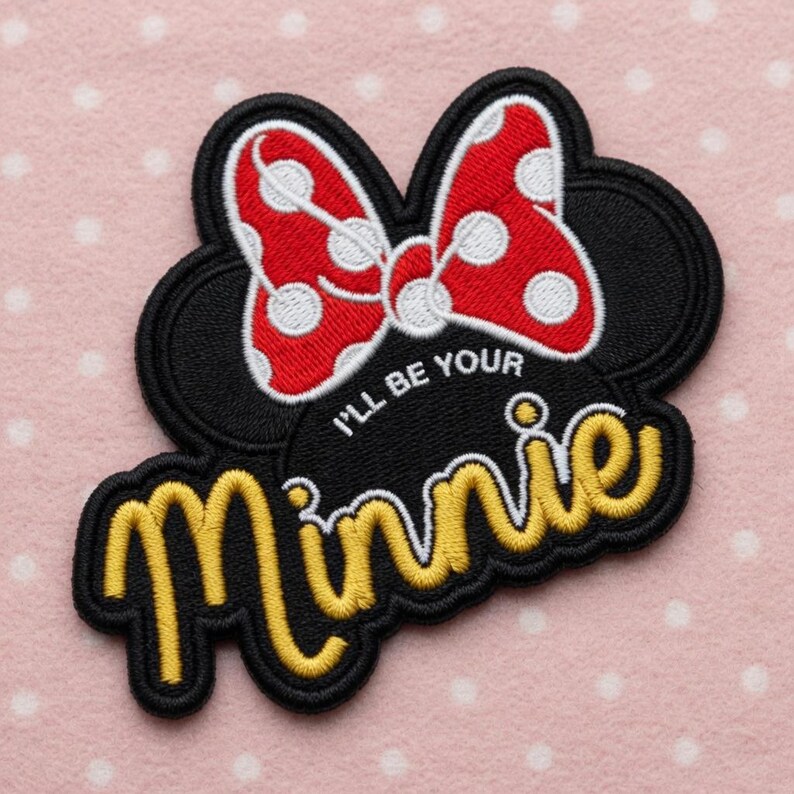 May include: Embroidered patch with a black Mickey Mouse ears silhouette and a red polka-dot bow. The patch has the text "I'll be your Minnie" in yellow script with a black outline.