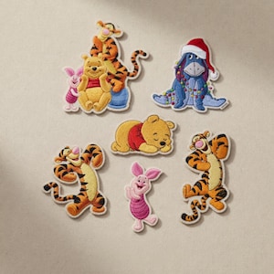 May include: Embroidered patches of Winnie the Pooh characters. The set includes Pooh Bear, Tigger, Piglet, and Eeyore wearing a Santa hat. The patches are in various poses and colours, with a white border.