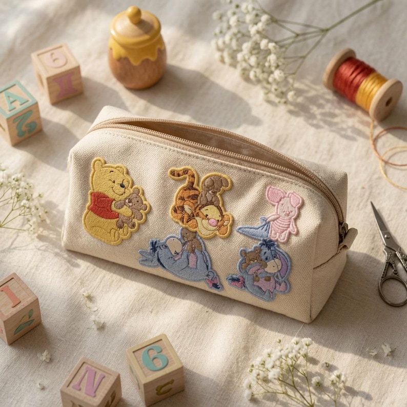 May include: A beige canvas pencil case featuring embroidered patches of Winnie the Pooh, Tigger, Piglet, and Eeyore. The rectangular pouch has a top zipper closure and a structured design, showcasing detailed character illustrations on the front panel.