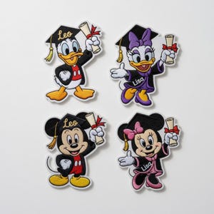 Puede incluir: Cuatro parches bordados con personajes de Disney con atuendo de graduaci&oacute;n. Donald Duck, Daisy Duck, Mickey Mouse y Minnie Mouse se representan con gorros de graduaci&oacute;n y diplomas. Cada parche tiene un nombre en la toga o gorro de graduaci&oacute;n.
