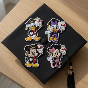 Puede incluir: Un birrete negro con cuatro parches de personajes de Disney: Pato Donald, Daisy, Mickey Mouse y Minnie Mouse. Cada personaje lleva un gorro de graduaci&oacute;n y sostiene un diploma. Los parches tienen nombres personalizados.
