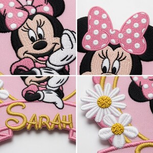 Puede incluir: Un parche bordado rosa que presenta a Minnie Mouse con un lazo de lunares, margaritas blancas con centros amarillos y el nombre Sarah bordado en hilo dorado. El dise&ntilde;o incluye un detallado trabajo de hilo negro, blanco y rosa sobre tela.