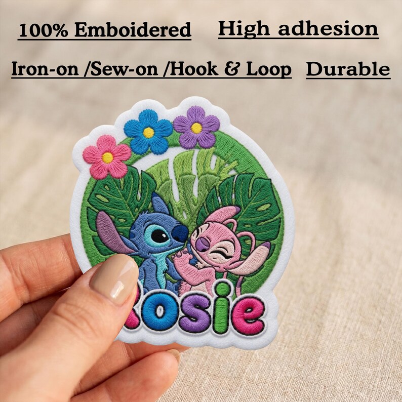 May include: A circular embroidered patch featuring blue and pink cartoon characters against a green tropical leaf background with three small flowers at the top. The name Rosie is stitched in colorful letters at the bottom. Text includes 100% Emboidered, High adhesion, Iron-on /Sew-on /Hook & Loop, and Durable.