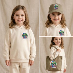 May include: A cream-colored hooded sweatshirt, a khaki baseball cap, and a khaki tote bag. Each item features a circular patch with a blue and pink cartoon character graphic, colorful flowers, and the name Rosie printed in pink lettering.