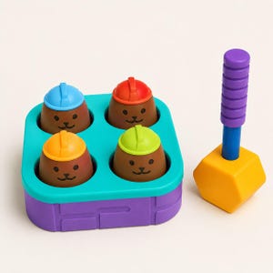 May include: A colorful toy featuring four brown figures wearing blue, red, orange, and green hard hats, set in a teal and purple base. A yellow hammer with a purple handle is positioned to the side. This toy is designed for children.