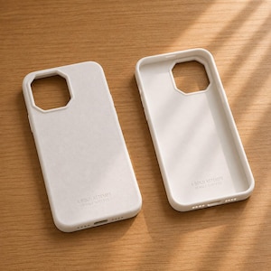 May include: Two white smartphone cases with a matte finish, each featuring a large square camera cutout. The text A BOLD ATTEMPT IS HALF SUCCESS is printed in small, clean lettering near the bottom of each case, which also includes speaker and charging port openings.