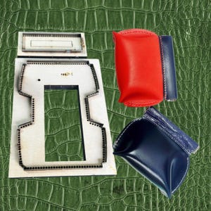 May include: A wooden die-cut template for leathercraft, alongside finished leather pouches in red, blue, and navy. The template has a rectangular shape with a central cutout and dotted edges. The pouches are various shapes and sizes.