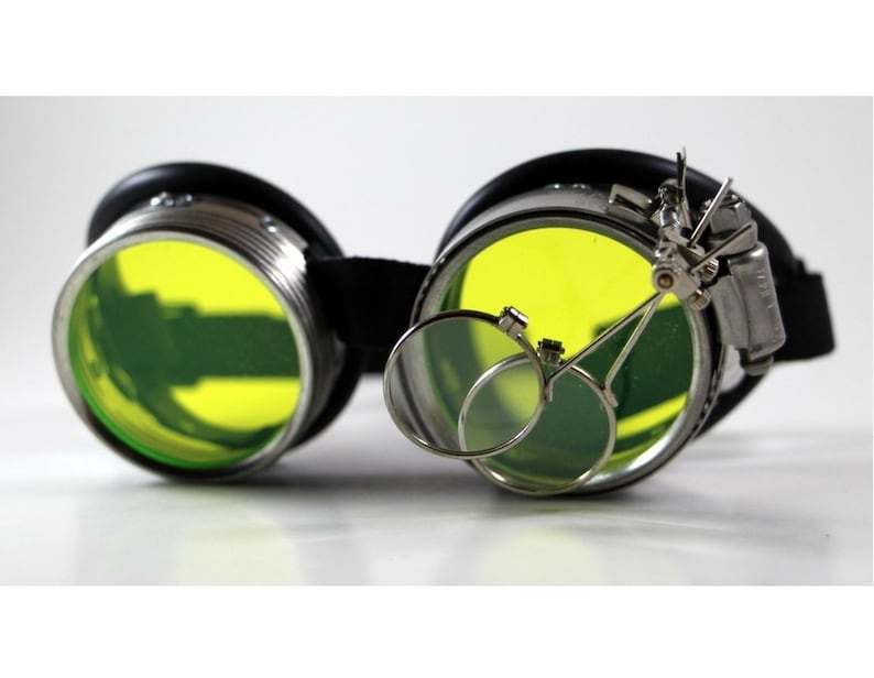 May include: Black steampunk goggles with yellow lenses and a magnifying glass attachment.