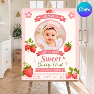 Peut inclure: Une affiche d'anniversaire rectangulaire avec une photo circulaire centrale d'un bébé portant un nœud rose, entourée d'illustrations de fraises, de rubans roses et du texte Welcome to Little Emma's Sweet Berry First Birthday Celebration.