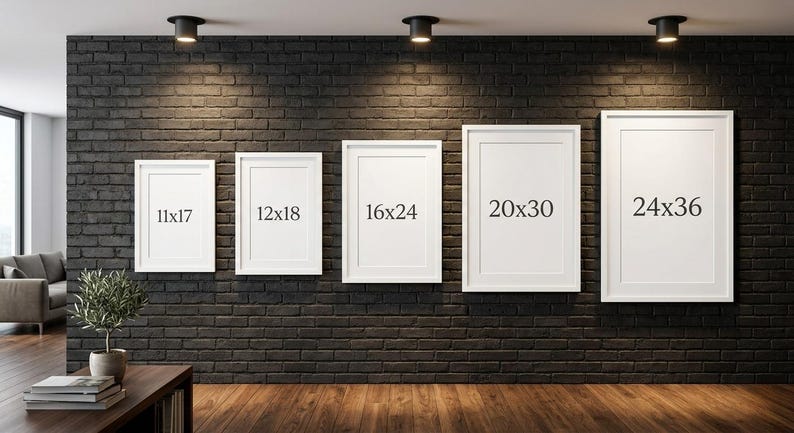 May include: Five white framed art prints of varying sizes are displayed on a dark brick wall. The sizes are labeled as 11x17 inches, 12x18 inches, 16x24 inches, 20x30 inches, and 24x36 inches. The room has a modern aesthetic with a wooden floor.