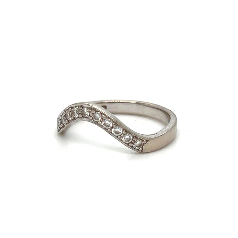 Puede incluir: Un anillo de plata con una banda ondulada y una fila de piedras de circonita c&uacute;bica transparentes.