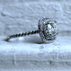 Anillo de compromiso con doble halo de diamantes clásicos y anillo de moissanita de cojín en oro blanco de 14 qt.