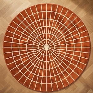 May include: A circular rug featuring a deep burnt orange background with a geometric pattern of thin, cream-colored lines radiating from the center, creating a series of concentric rings and rectangular segments across the entire surface.