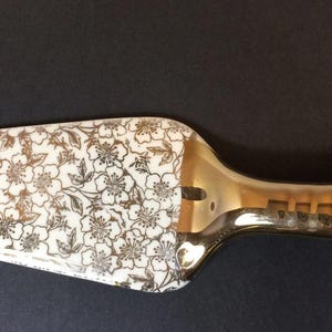 May include: A white ceramic mug with a black handle and the text "But First, Coffee" in a black, handwritten-style font. The mug is on a white surface.