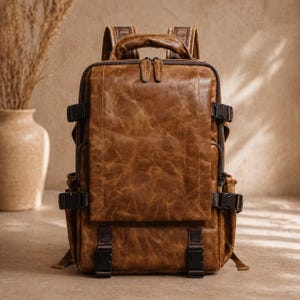 May include: A brown leather backpack with multiple compartments and adjustable straps. The backpack features a top handle, side pockets, and secure buckle closures. The leather has a distressed, textured appearance.
