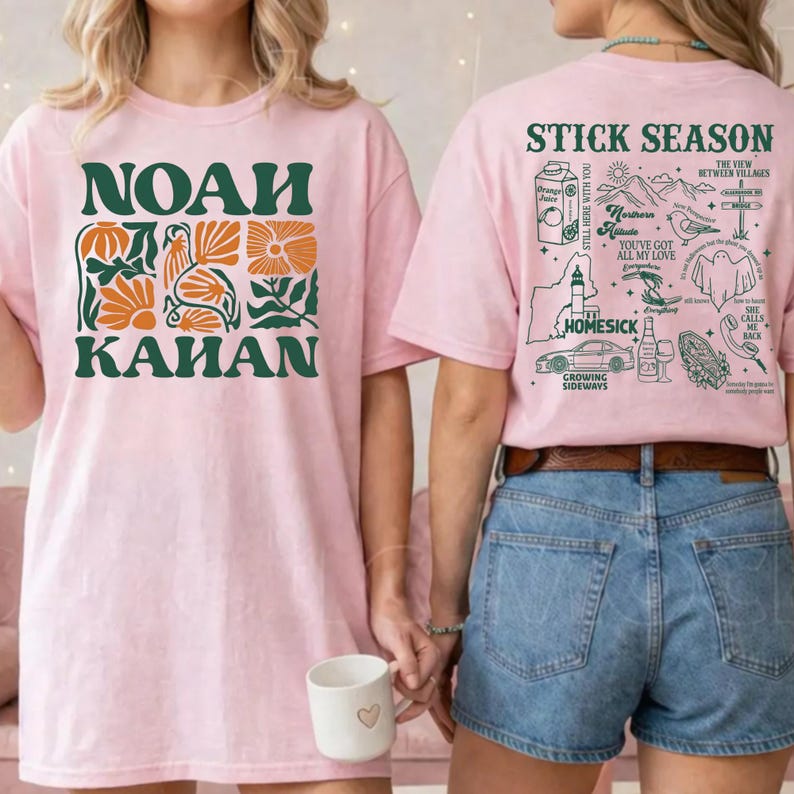 Może przedstawiać: Dwie r&oacute;żowe koszulki. Jedna ma napis "NOAH KAHAN" w kolorze zielonym z pomarańczowymi kwiatowymi akcentami. Druga ma napis "STICK SEASON" i inne ilustracje. Koszulki noszą dwie osoby.
