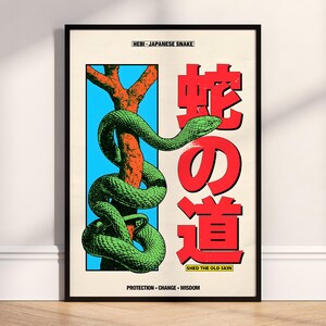 Op de afbeelding: Een ingelijste poster met een groene slang die zich om een oranje tak wikkelt tegen een blauwe achtergrond. Japanse tekst in het rood wordt weergegeven, met de woorden "HEBI - JAPANESE SNAKE" bovenaan en "SHED THE OLD SKIN" onderaan. De poster zit in een zwarte lijst.