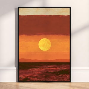 Könnte beinhalten: Ein gerahmter, rechteckiger Wandkunstdruck mit einer horizontalen Landschaftskomposition. Die Szene zeigt eine leuchtend gelbe Sonne, die vor geschichteten Bändern in Orange- und Dunkelrottönen zentriert ist, mit einem dunklen, texturierten Meer.