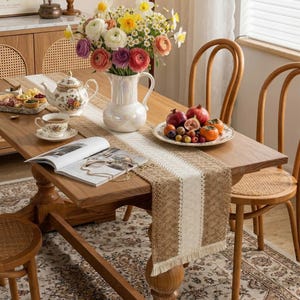 Puede incluir: Un letrero de madera hecho a mano con la palabra "Bienvenido" en una fuente juguetona. El letrero está pintado de blanco con un acabado envejecido y presenta un diseño floral en tonos rosas y verdes. Mide aproximadamente 30 cm de ancho y 15 cm de alto.