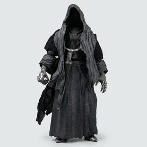 Puede incluir: Figura de acción detallada de una figura con capa en gris oscuro y negro. La figura tiene una capa con capucha, una túnica larga y guanteletes metálicos. La figura está de pie sobre un fondo blanco liso.