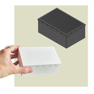 May include: A rectangular box with a perforated top lid and a scalloped edge detail along the upper rim. The box is shown in two versions: one in solid white and one in solid dark grey, both featuring a grid of small holes on the top surface.