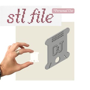 Puede incluir: Un modelo 3D digital de una bobina de hilo gris con las letras CJ y un patrón de cuadrícula, mostrado junto a una pequeña bobina de hilo blanca física. La imagen incluye el texto stl file y Personal Use en un estilo de fuente de punto de cruz.