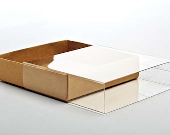 May include: A rectangular box with a clear plastic lid. The box is made of brown cardboard and has a white interior. The lid is partially open, revealing the contents of the box.