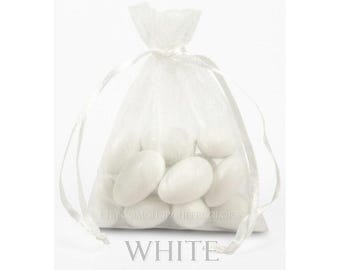 May include: A small, semi-transparent white organza drawstring bag filled with several smooth, oval-shaped white candies. The bag is cinched at the top with a matching white ribbon. The text "WHITE" is printed in large letters at the bottom.