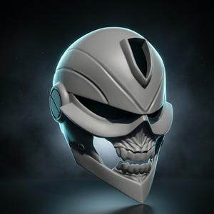May include: A matte grey helmet featuring a stylised skull design on the lower face section. The helmet has a smooth, contoured upper shell with a central ridge, integrated side circular details, and a wide visor opening above the teeth.