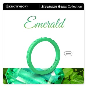 May include: A green silicone ring with a textured, faceted design. The ring is 2 mm thick and is part of the Stackable Gems Collection. The ring is shown on top of a green emerald gemstone.