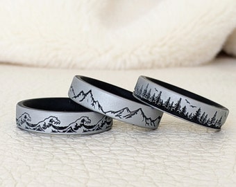 May include: Three silicone rings with different nature-inspired designs. The first ring features a wave pattern, the second ring has a mountain range design, and the third ring has a forest silhouette.